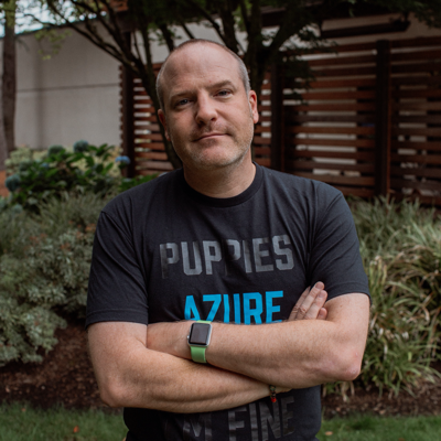 Jim with his arms folded wearing a dark t shirt